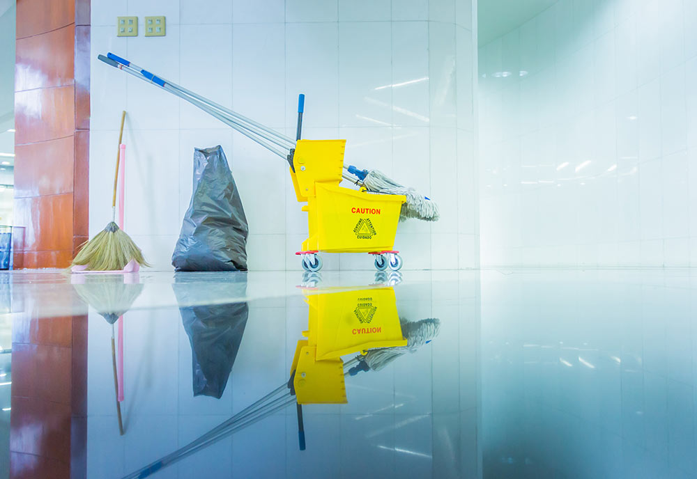 A mop bucket and trash bag shows the signs of a cleaning job finished and well-done.